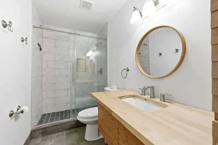 Bathroom featuring a wood-finish vanity with integrated rectangular sink and brushed nickel fixtures