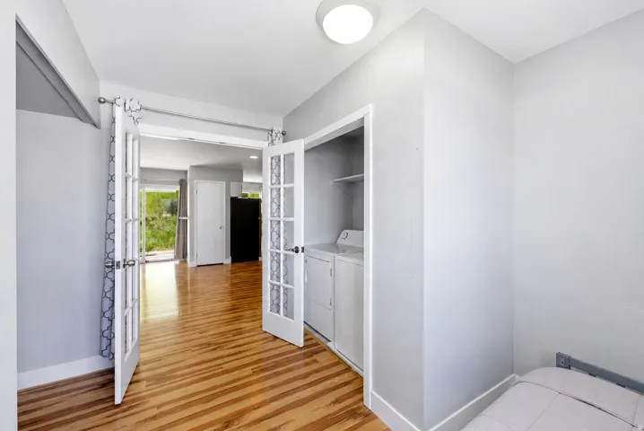 Interior space featuring wood-finish flooring, light gray wall paint, and white trim