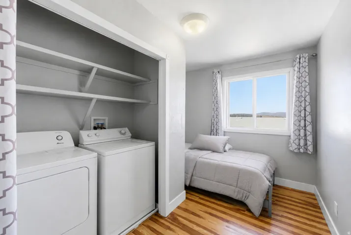 Compact laundry area featuring a washer and dryer, complemented by overhead shelving for storage