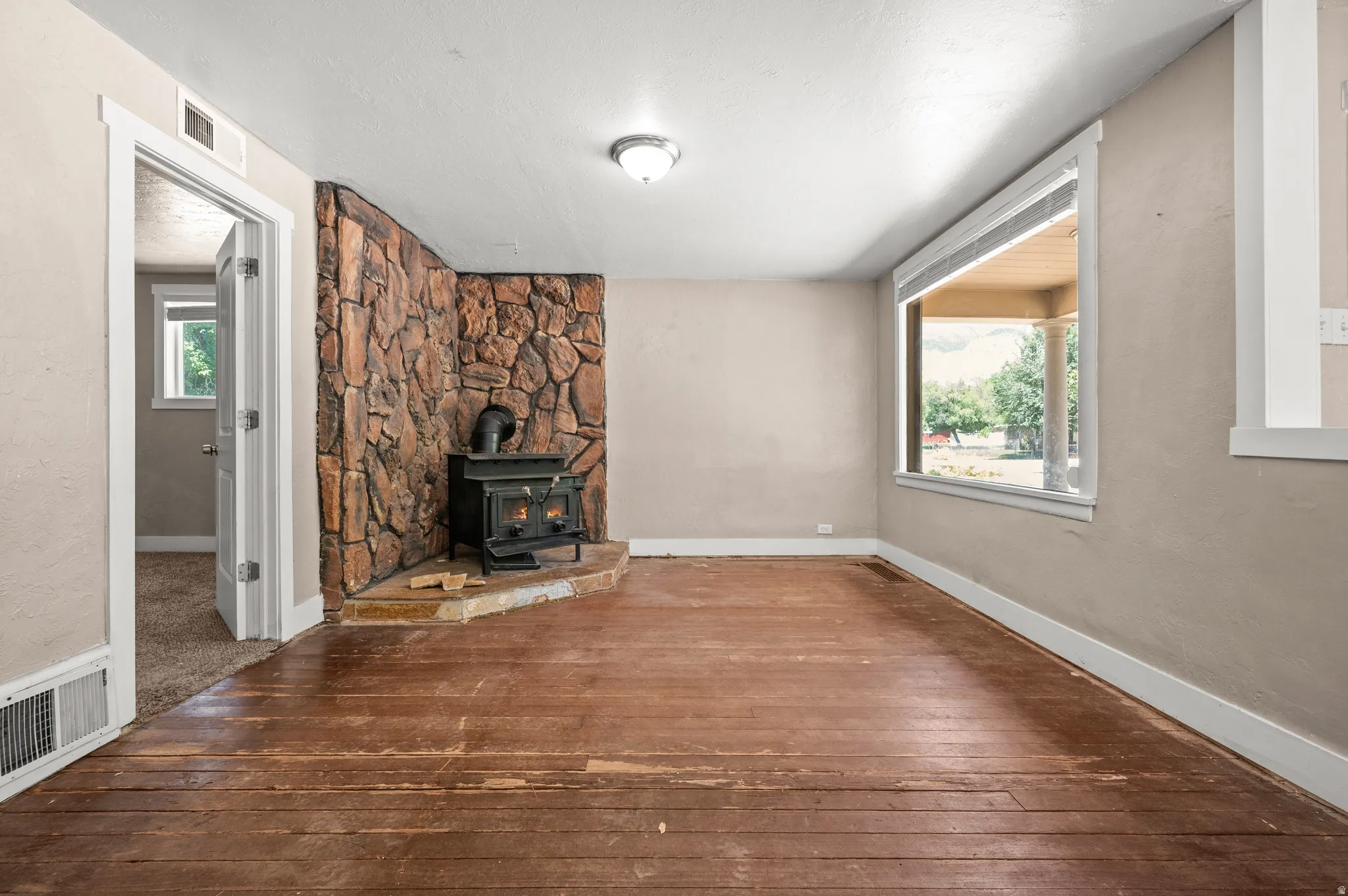 Living area with a stone-accented wall and a black wood-burning stove on a corner hearth