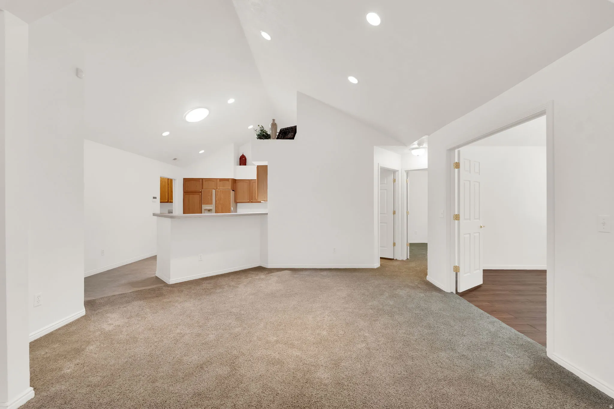 Spacious interior featuring a vaulted ceiling and recessed lighting