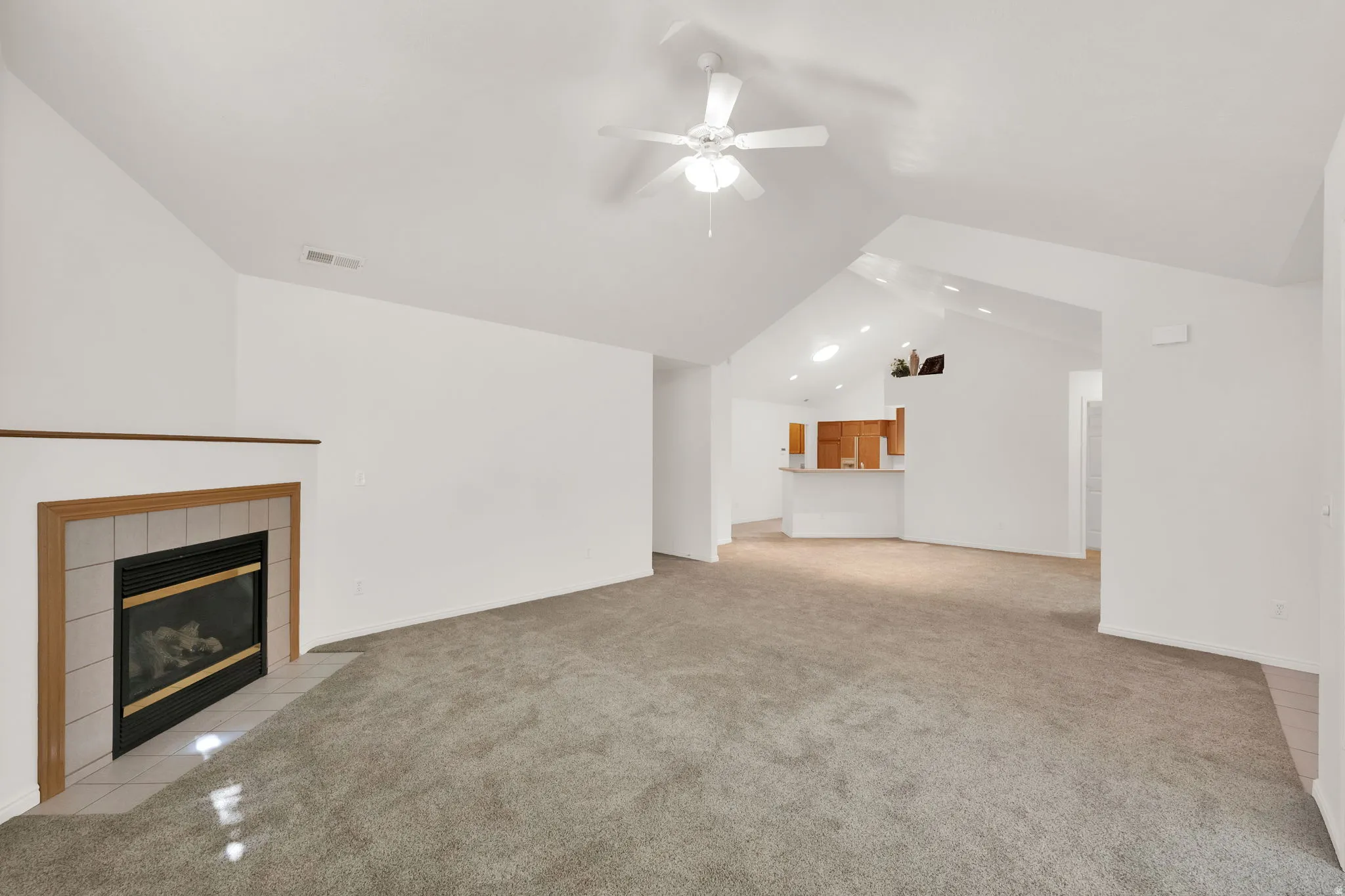 Living room featuring a fireplace with a light-toned tile surround and wood mantel