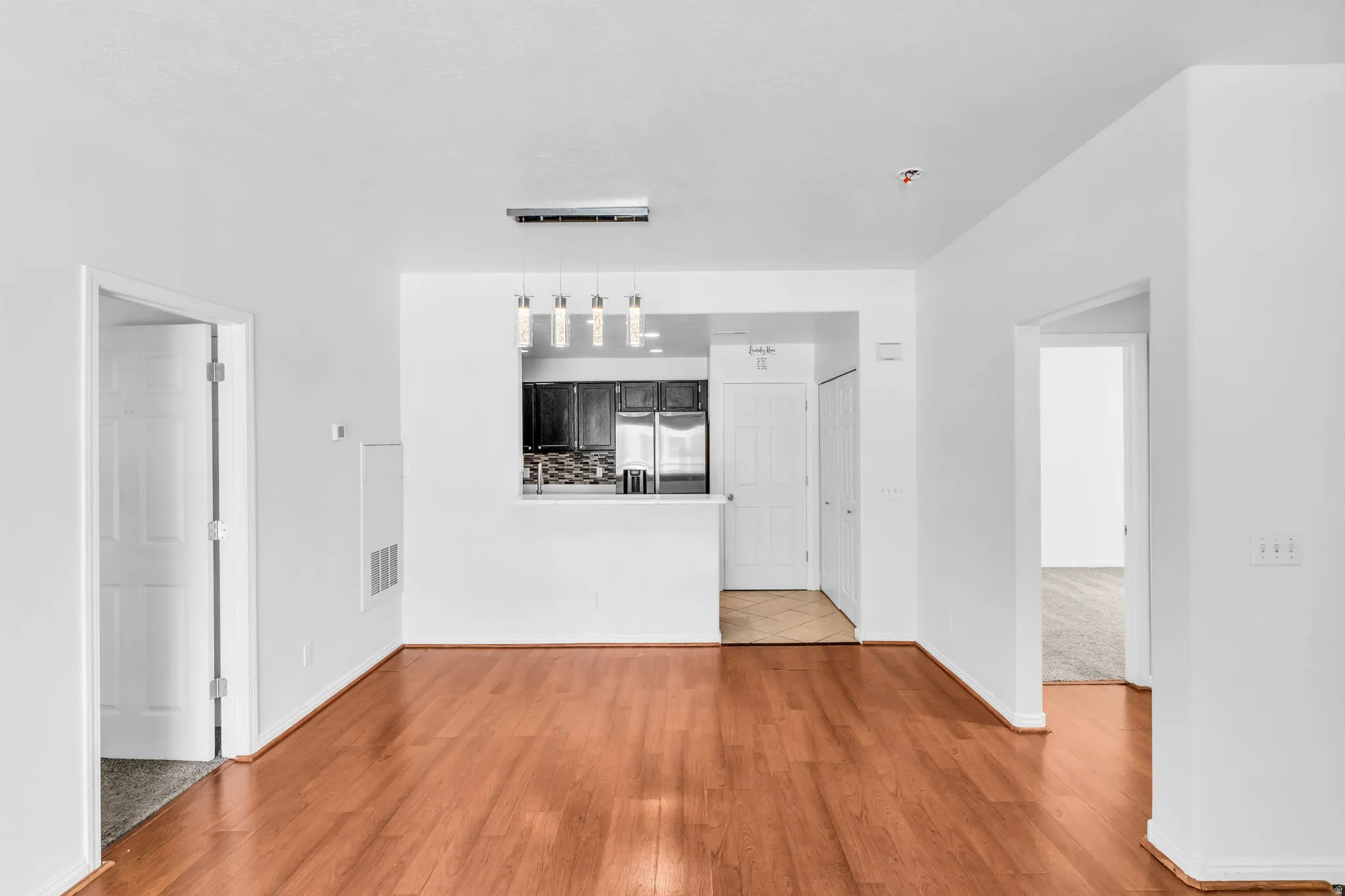 Open concept living space featuring wood-finish flooring, white walls, and recessed lighting
