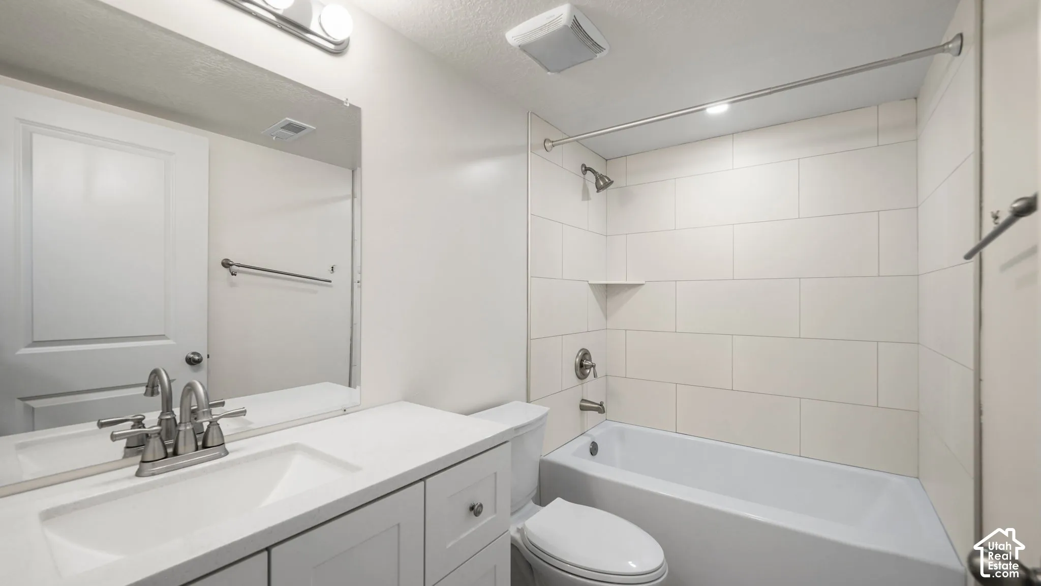 ADU ensuite Bathroom-1 of 2 Bathrooms in ADU--  with White Quartz vanity with integrated sink, brushed nickel faucet, large wall mirror, white subway tile shower surround, and integrated bathtub