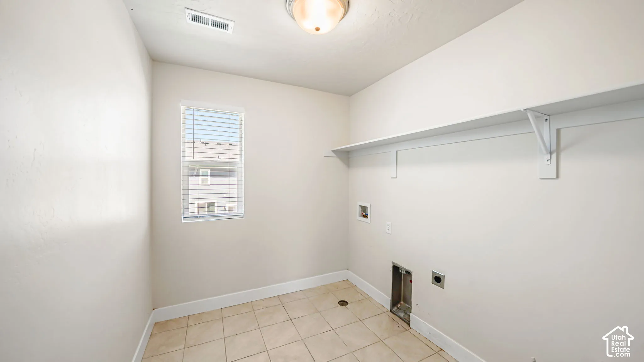 Spacious LAUNDRY ROOM conveniently located upstairs near the bedrooms has tiled flooring, overhead shelving