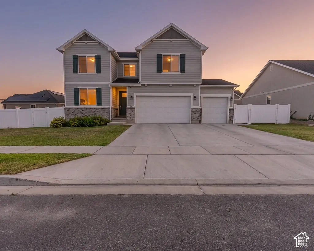 Two-story residence featuring beautiful dark green shutters, stone accents, and 3 car garage