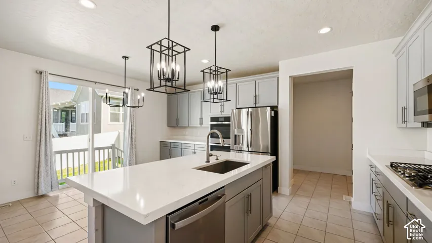Kitchen featuring a large island with custom Quartz countertops, Farmhouse sink, stainless steel appliances including top tier Refrigerator