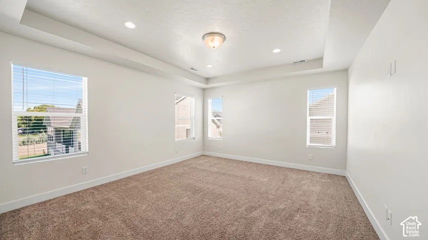 Large Master Bedroom #1 boasts a tray ceiling, recessed lighting, and neutral-toned carpeting