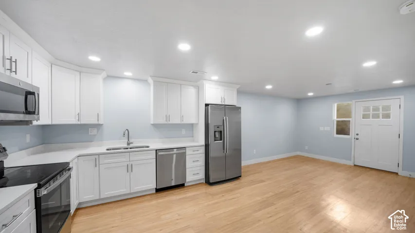 ADU Kitchen featuring white cabinetry, stainless steel appliances, solid surface countertops, and recessed lighting
