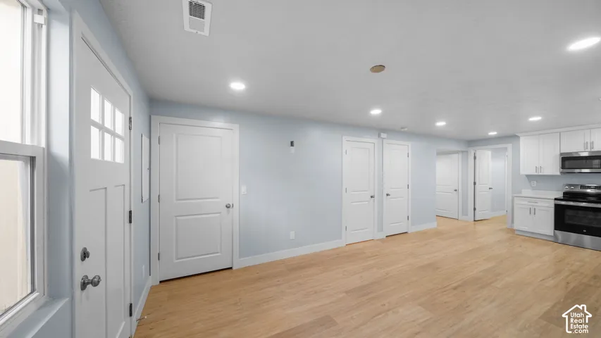 ADU features lots of bright recessed lighting for illumination; the open-concept living space, featuring LVP h flooring and light-toned wall paint