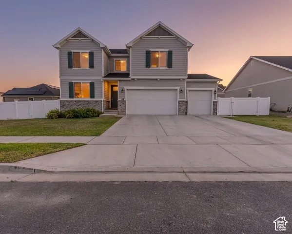 Two-story residence featuring beautiful dark green shutters, stone accents, and 3 car garage