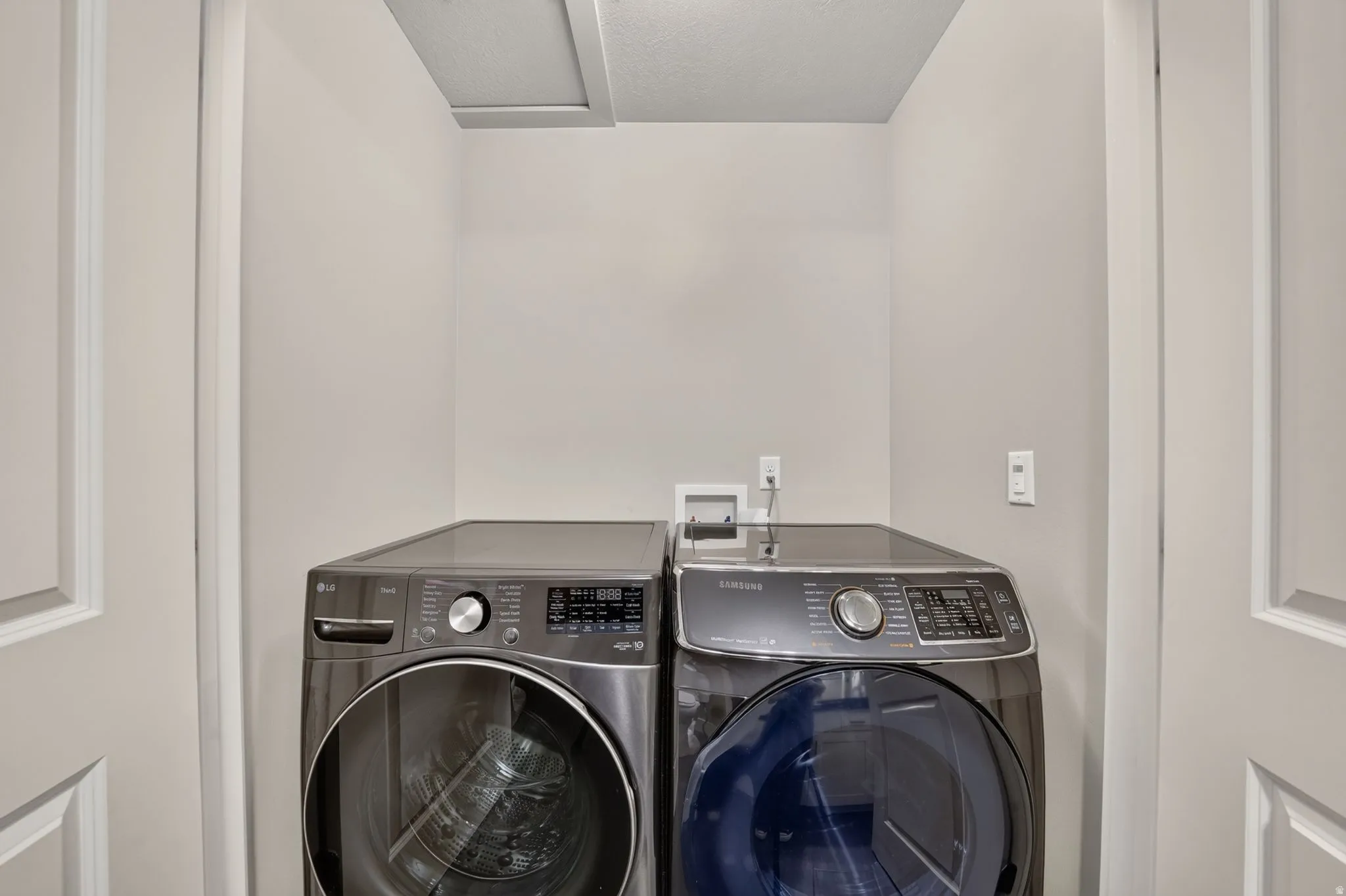 Dedicated laundry area featuring light neutral walls and a built-in access panel