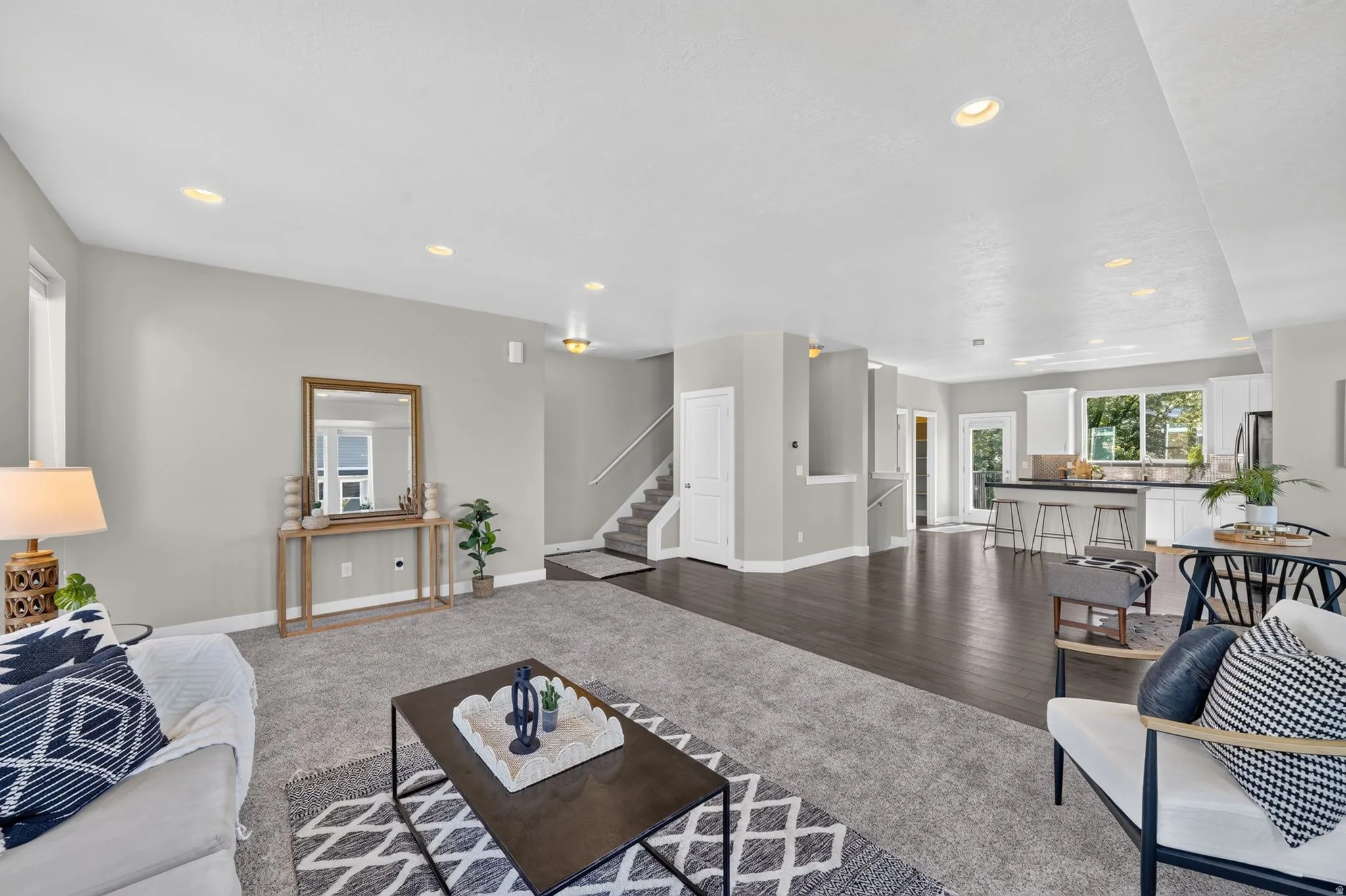 Open-concept living area featuring light gray wall paint, recessed ceiling lighting, and dark wood-finish flooring