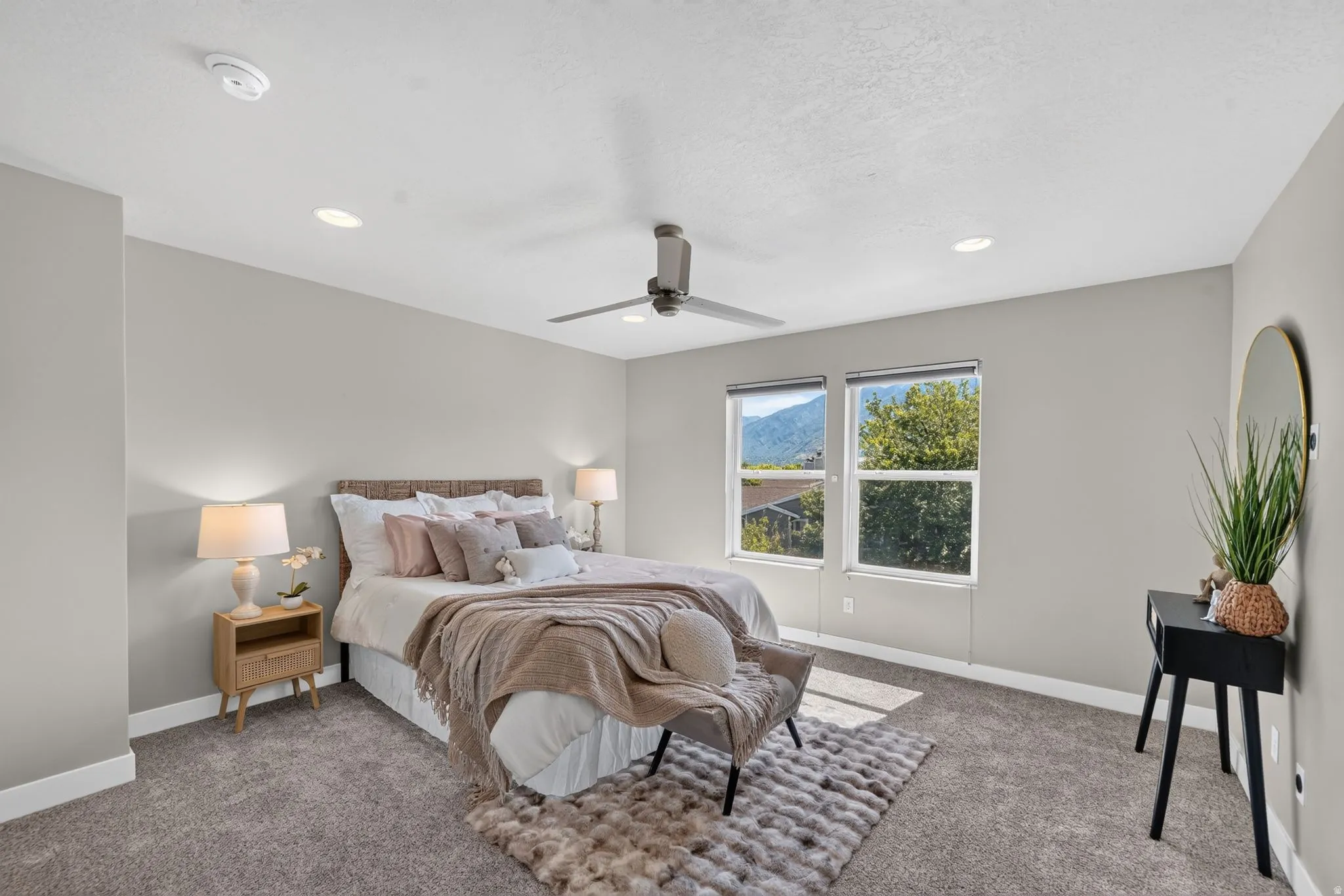 Carpeted bedroom featuring a ceiling fan with light, recessed lighting, and two windows