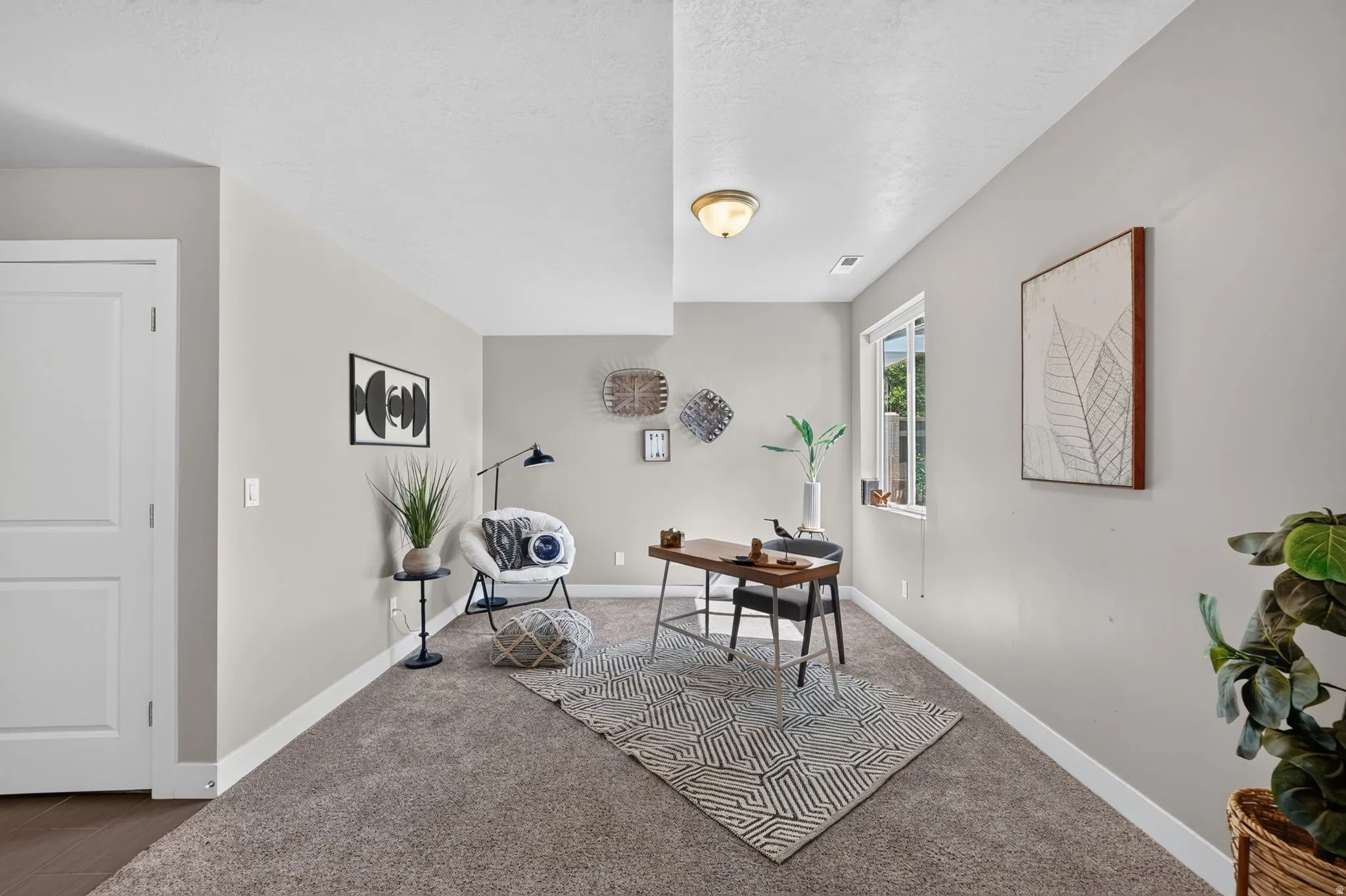 Spacious room featuring neutral-toned carpet flooring, light gray wall paint, and white trim