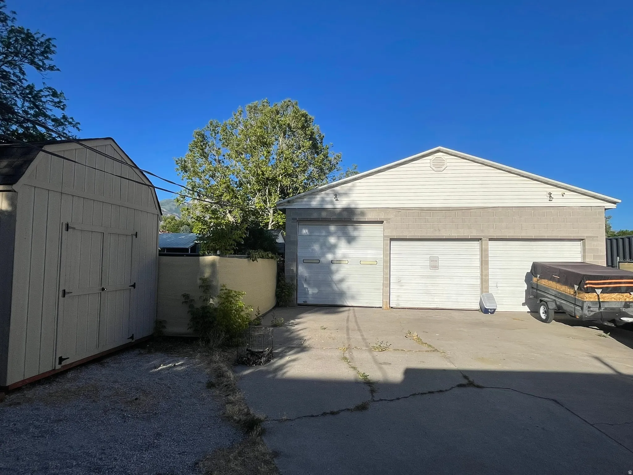 Detached garage structure featuring a two-bay garage door, two-tone exterior siding, and a gabled roofline