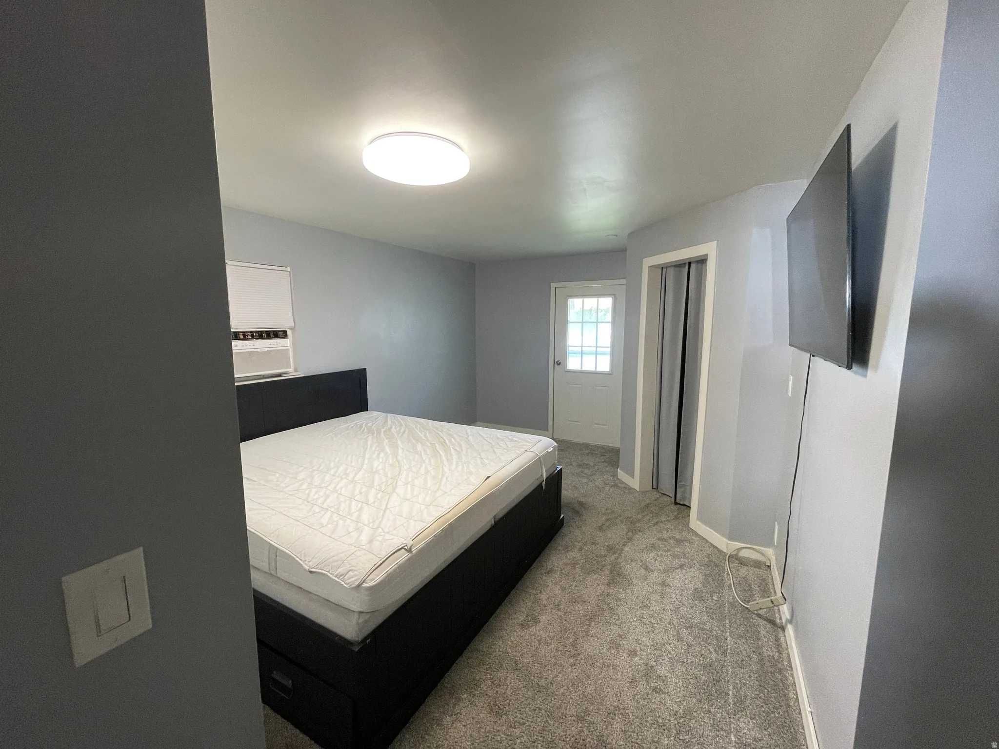 Bedroom featuring light gray walls, gray carpeting, and a white ceiling-mounted light fixture