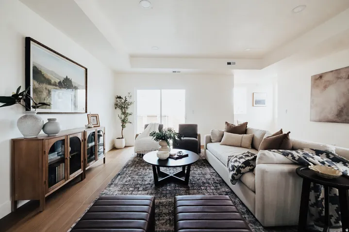 Expansive living area featuring light wood-finish flooring, recessed lighting, and a neutral color palette