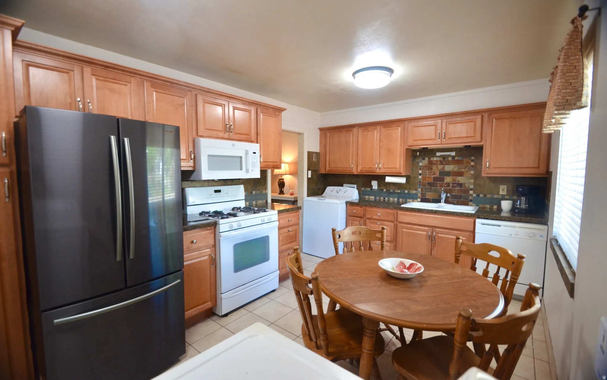 Kitchen featuring wood cabinetry, a decorative tile backsplash, recessed lighting, and tile flooring