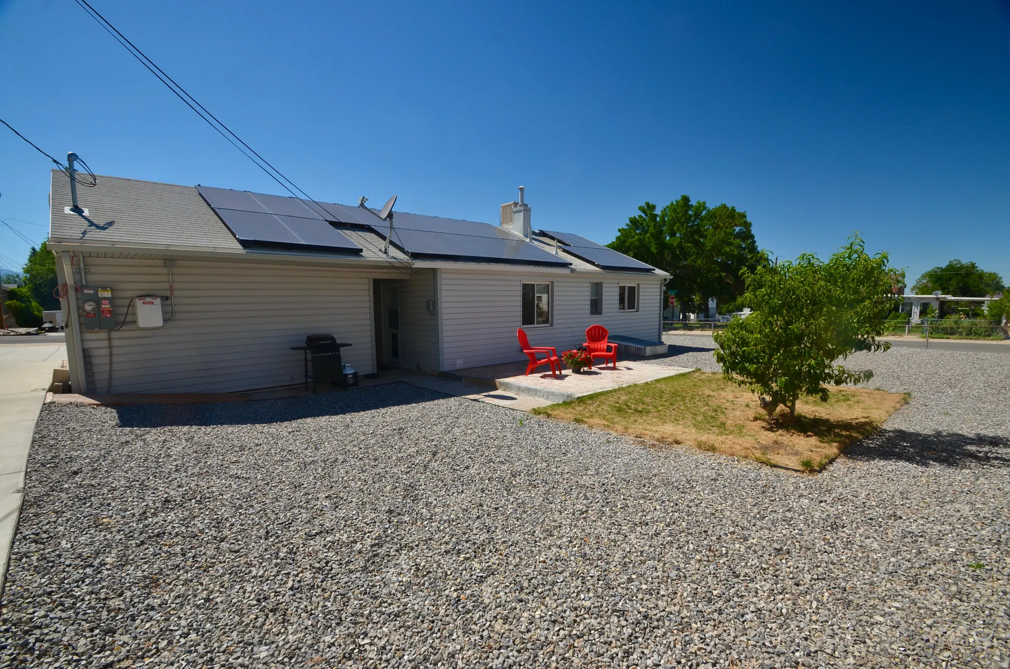 Exterior siding residence featuring a gravel yard and solar panel installation