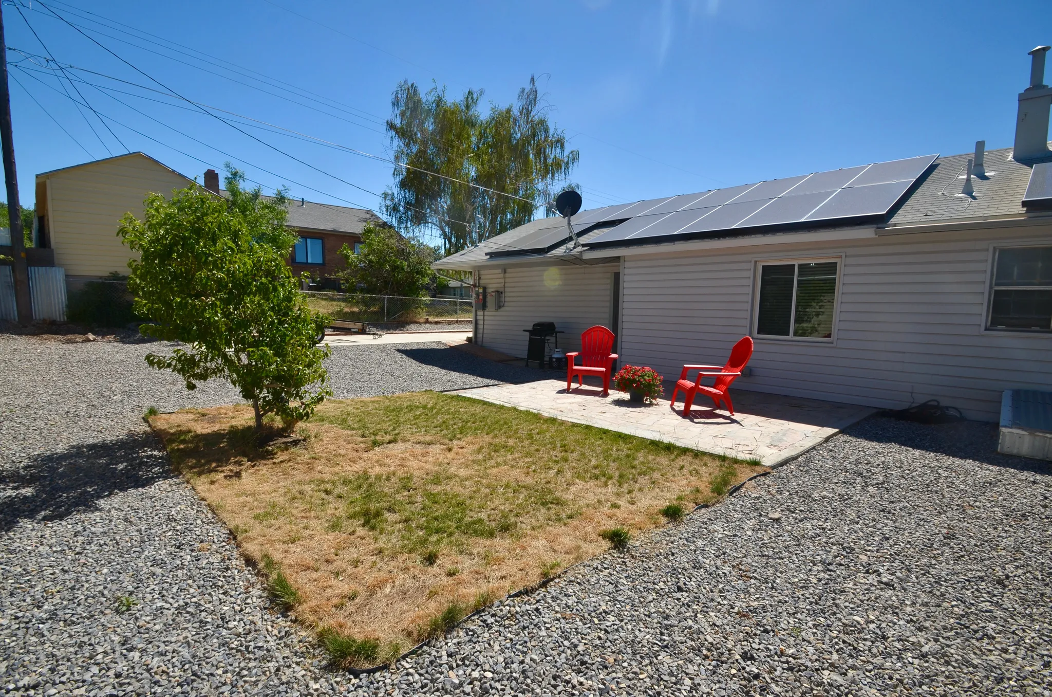Rear exterior featuring solar panels, siding, and a concrete patio