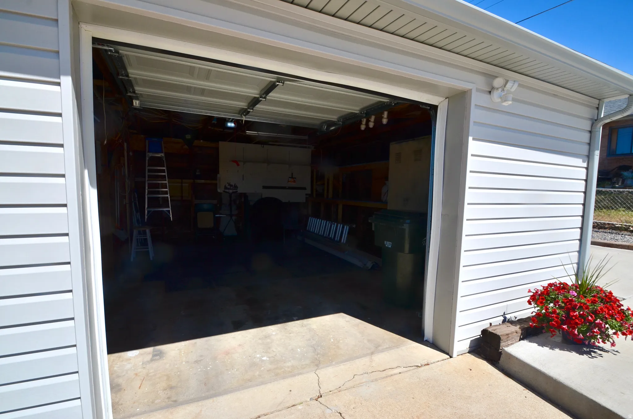 Attached garage featuring white horizontal siding, a concrete driveway approach, and an overhead garage door