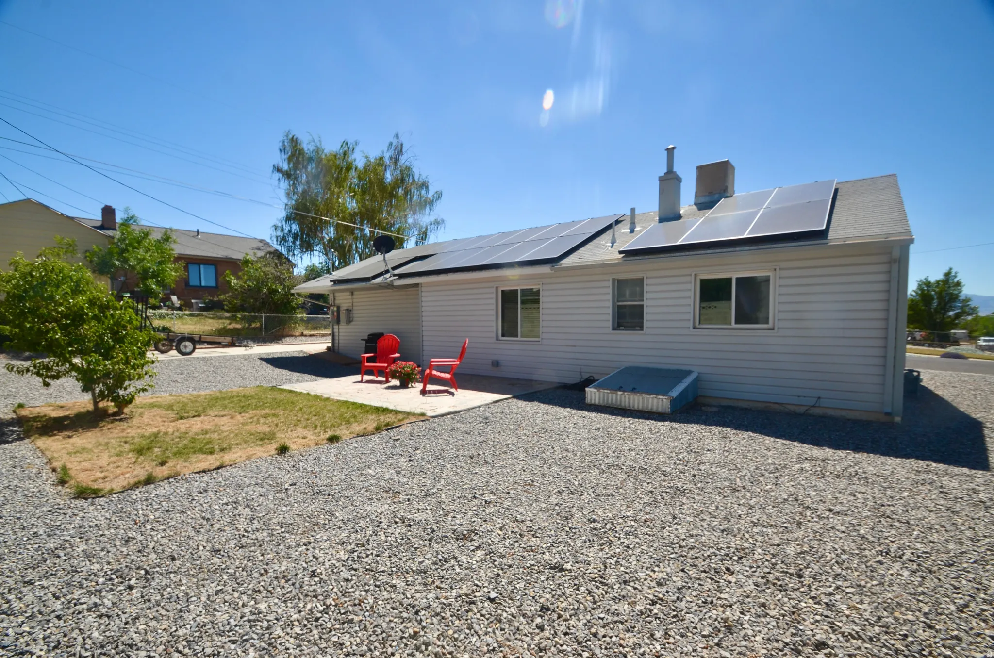 Rear exterior with light-colored siding and a gravel landscape