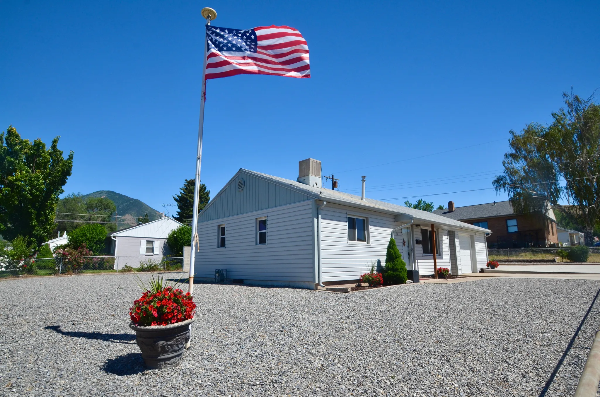 Property exterior featuring white siding, multiple windows, and a paved entrance