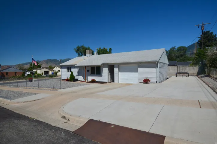 Ranch-style residence featuring white siding and a white shingle roof