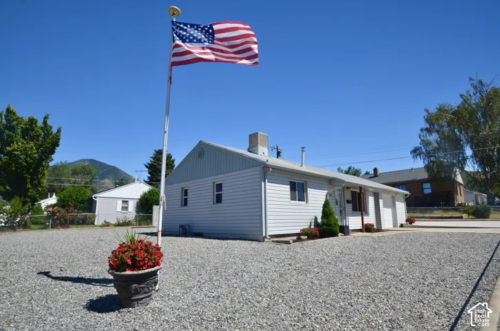 Property exterior featuring white siding, multiple windows, and a paved entrance