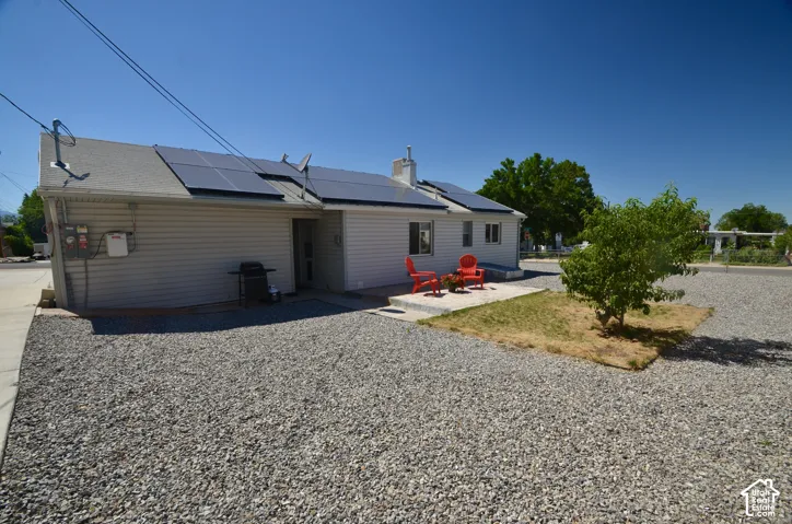 Exterior siding residence featuring a gravel yard and solar panel installation