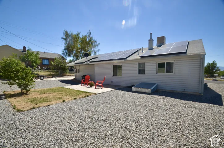 Rear exterior with light-colored siding and a gravel landscape