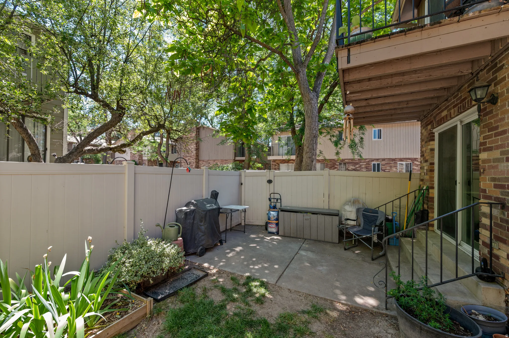 Private patio area featuring concrete paving and a privacy fence