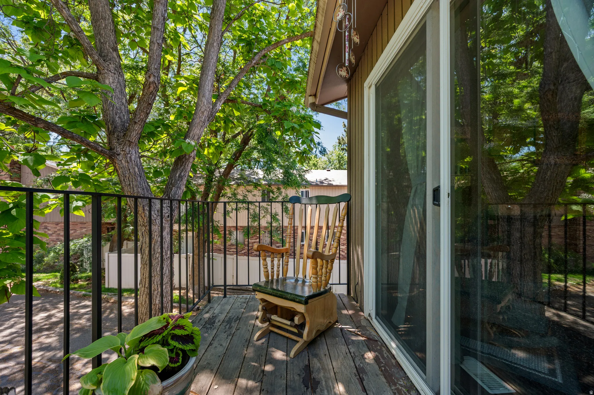 Private outdoor balcony featuring wood decking and black metal railings