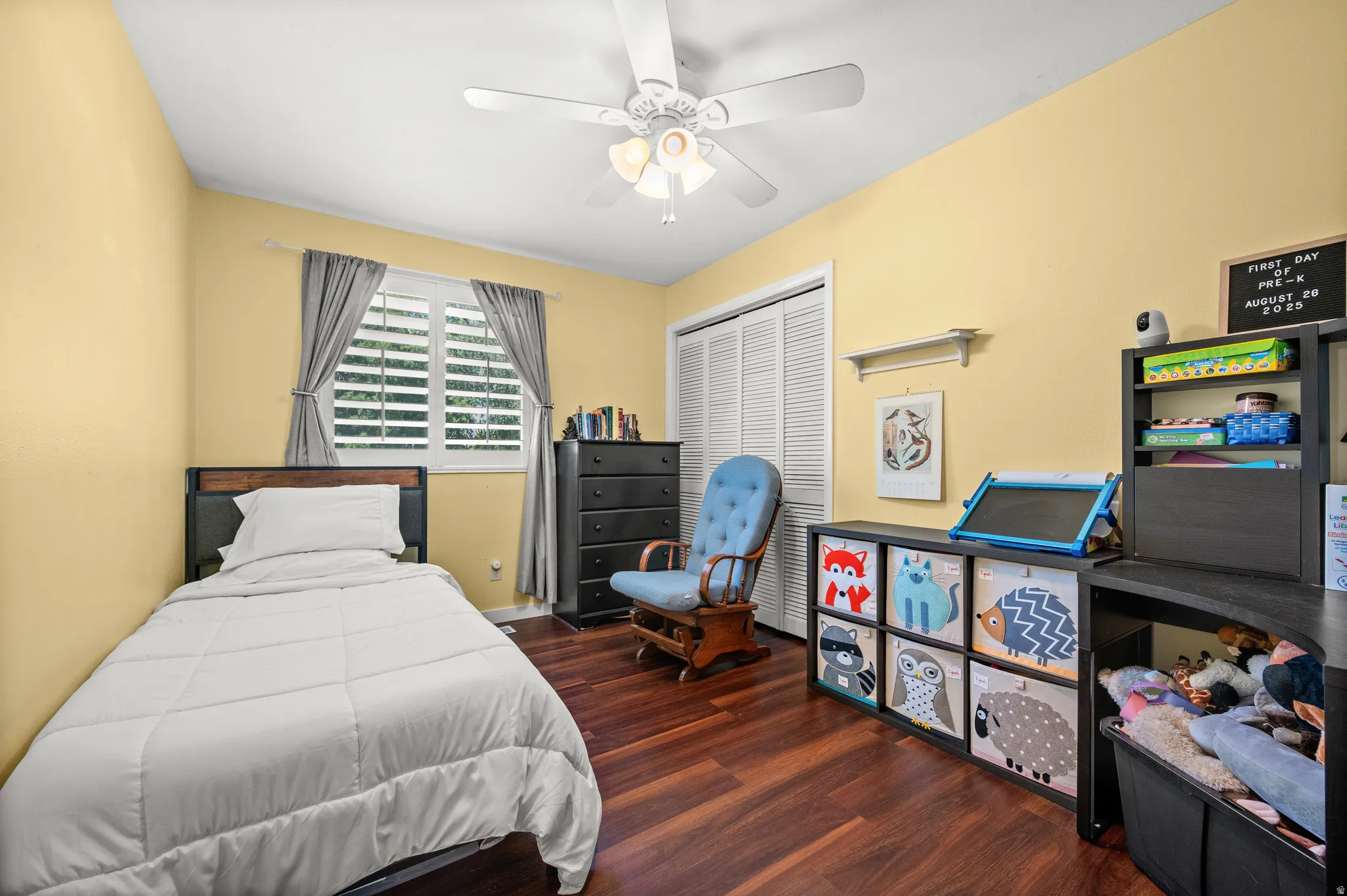 Interior room featuring wood-finish flooring, a vaulted ceiling, and light yellow walls