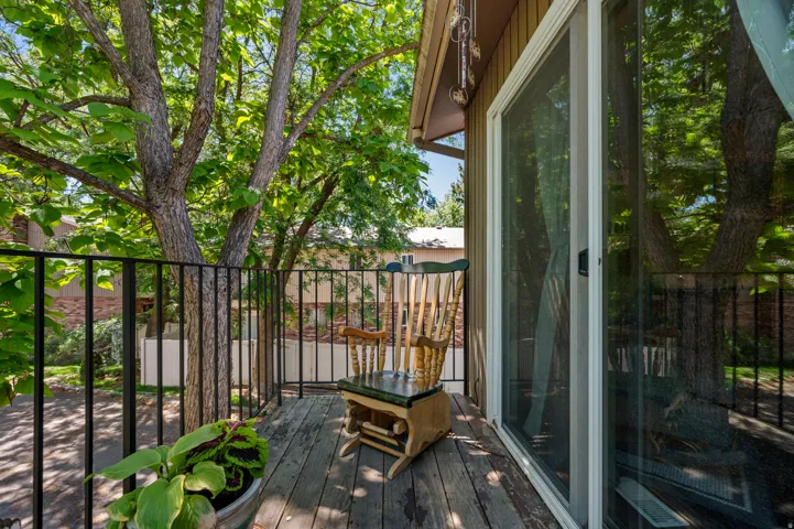 Private outdoor balcony featuring wood decking and black metal railings