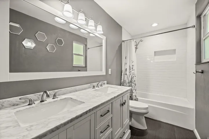 Bathroom featuring a double vanity with stone countertop, undermount sinks, and brushed nickel fixtures