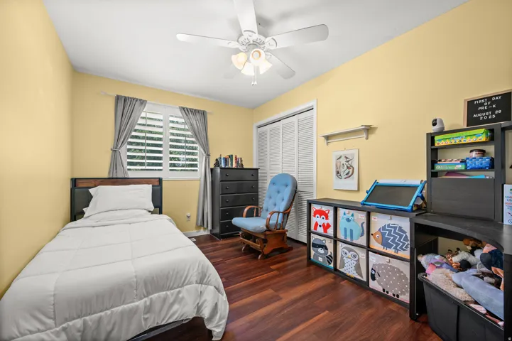 Interior room featuring wood-finish flooring, a vaulted ceiling, and light yellow walls