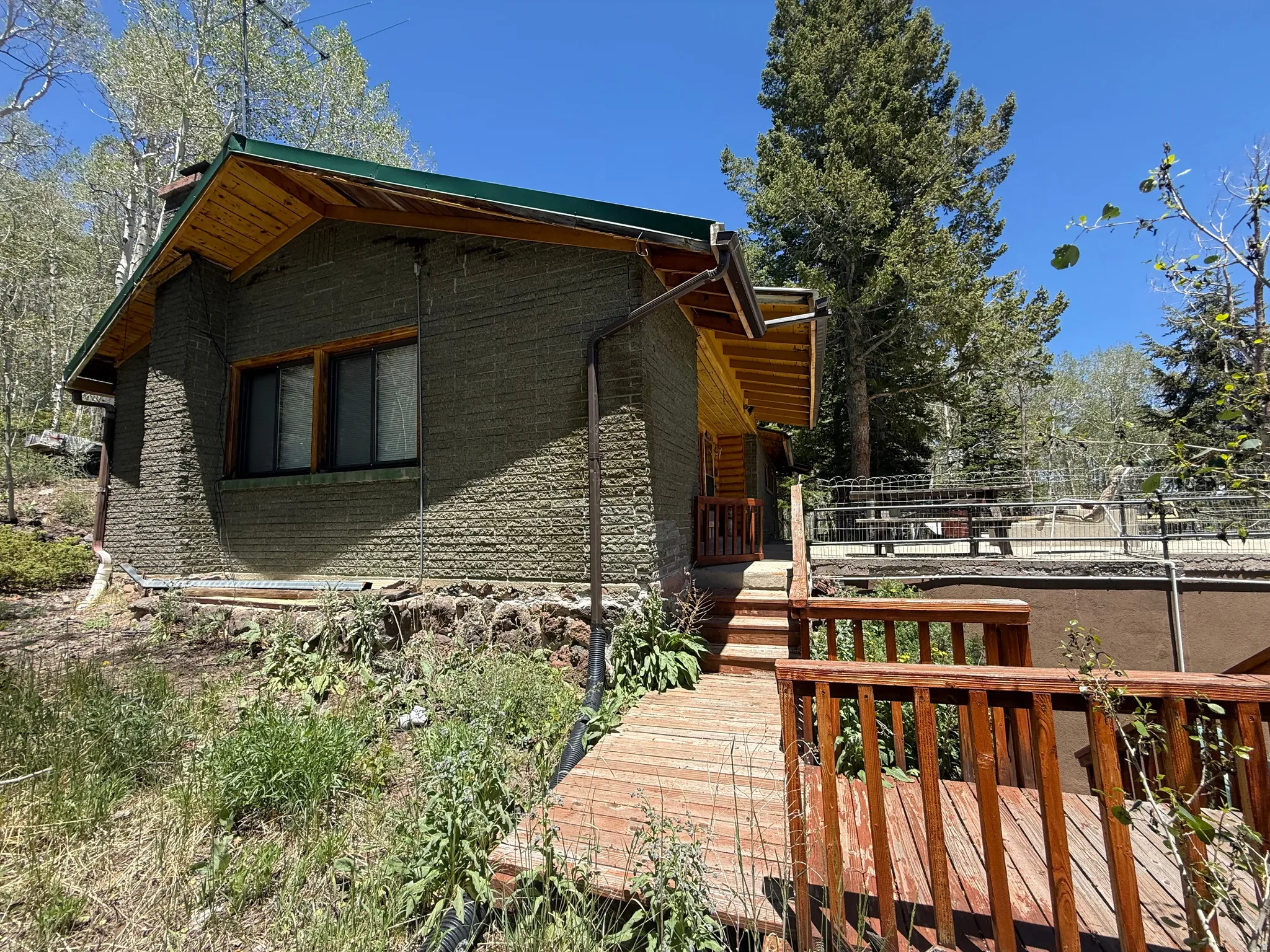 Exterior featuring unique textured siding and a green metal roof
