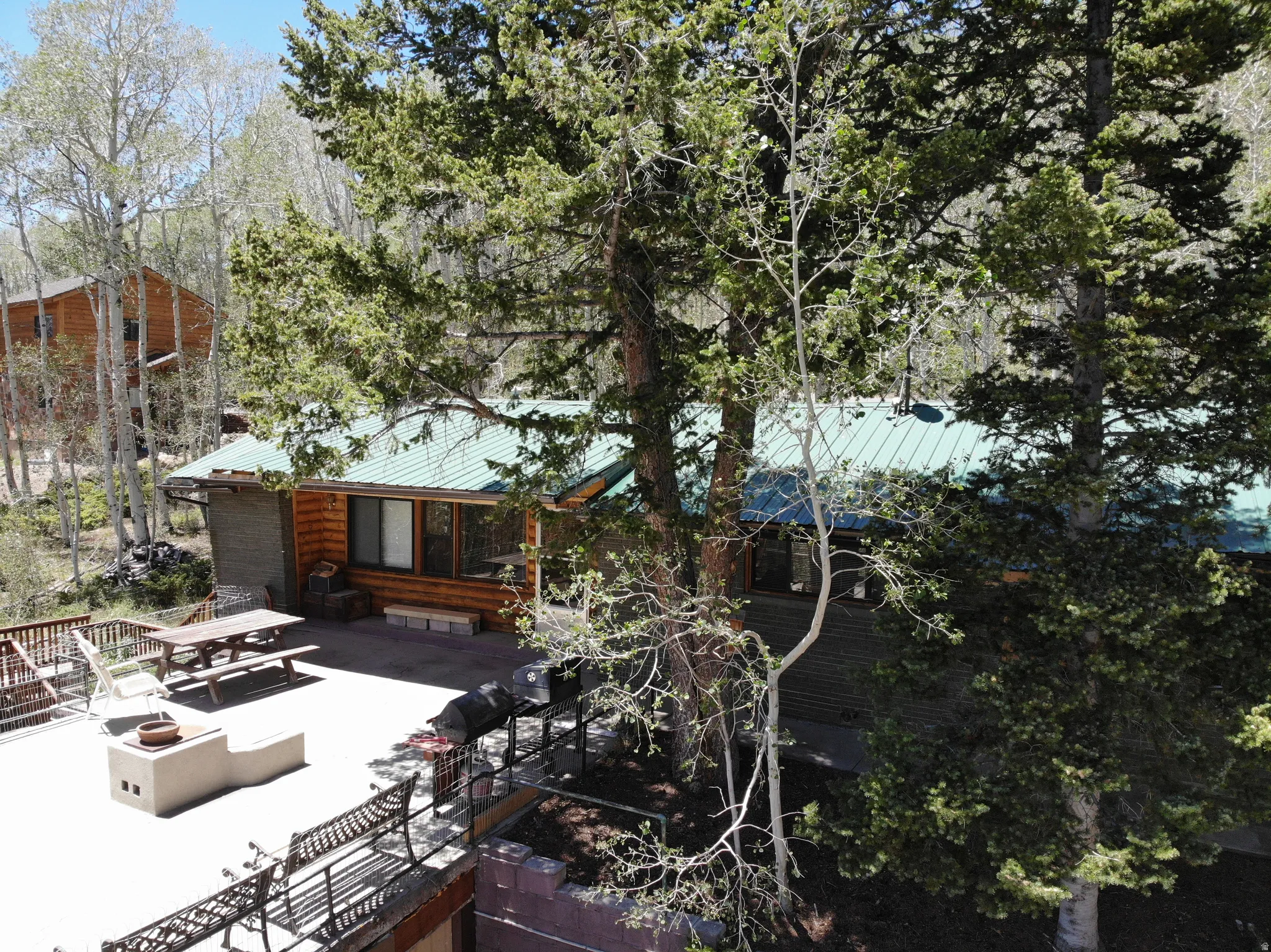 Log cabin-style residence featuring a green metal roof