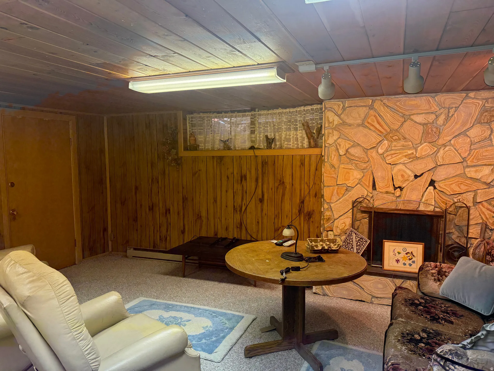 Stone-clad fireplace with metal grate and dark interior