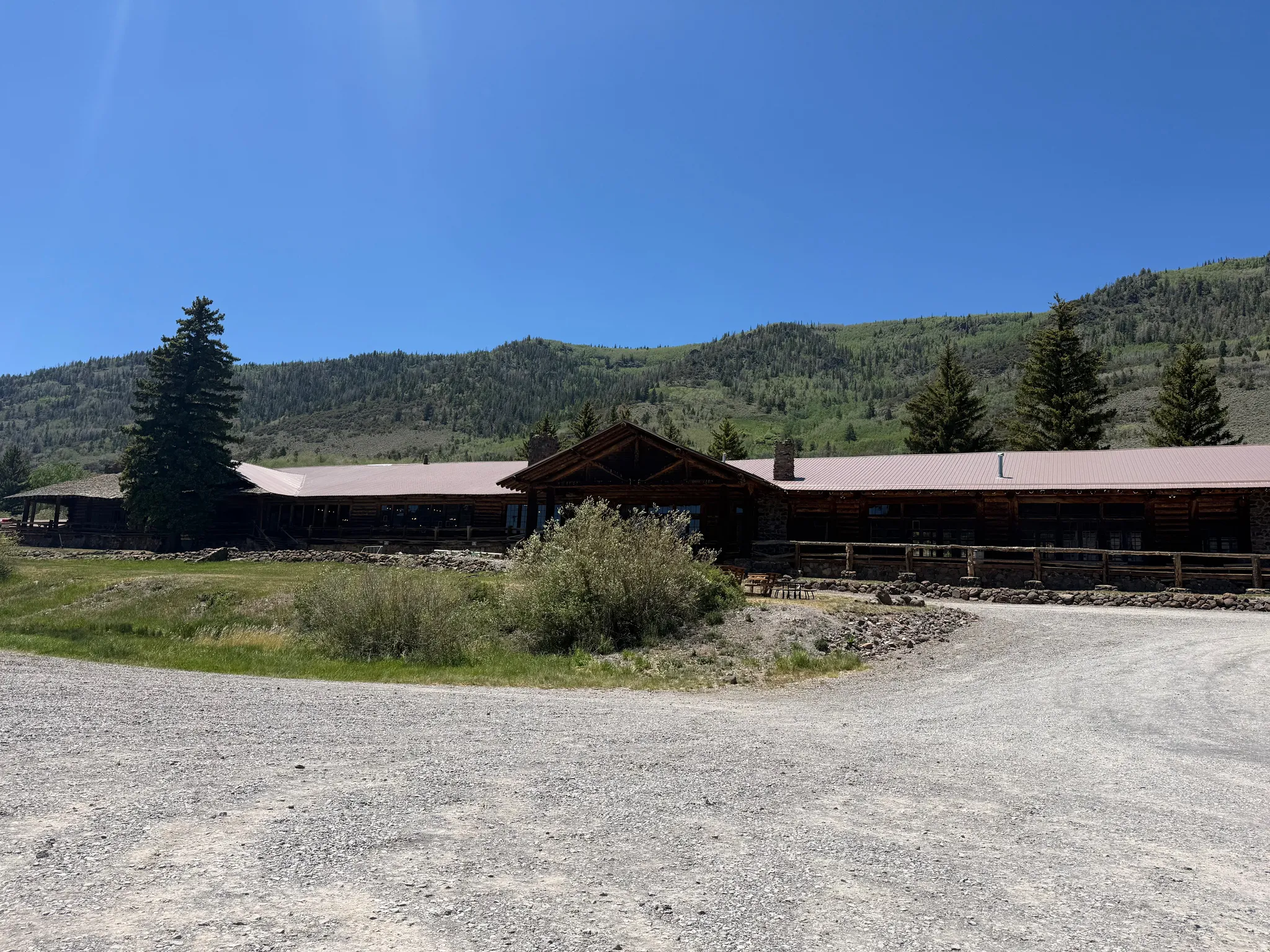 Rustic log and stone exterior featuring an expansive metal roof