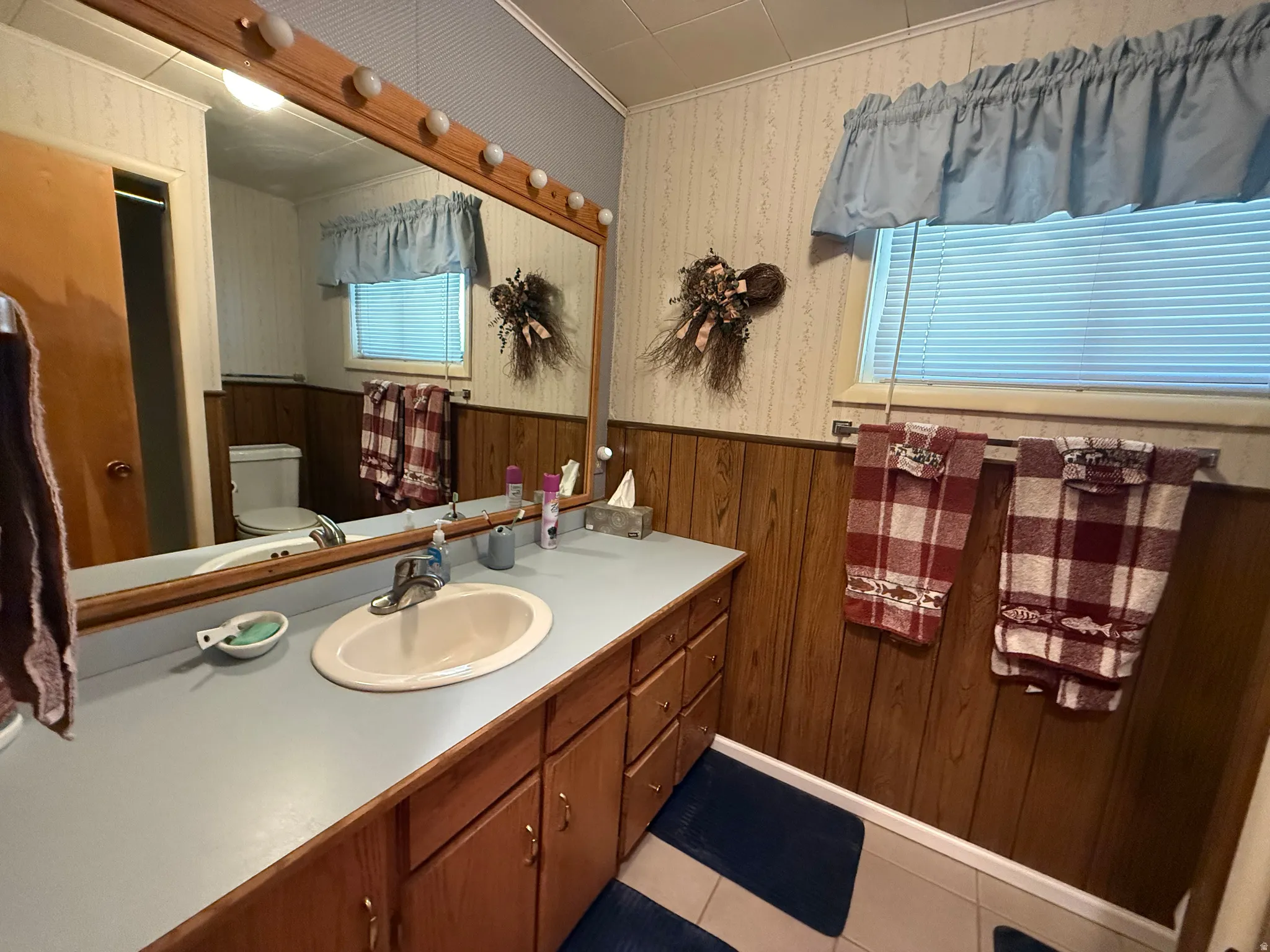 Bathroom vanity featuring an integrated sink, laminate countertop, and wood-finish cabinetry