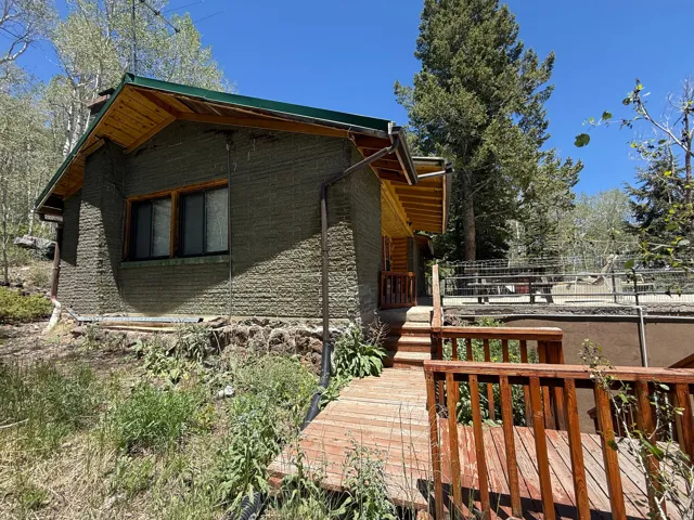 Exterior featuring unique textured siding and a green metal roof