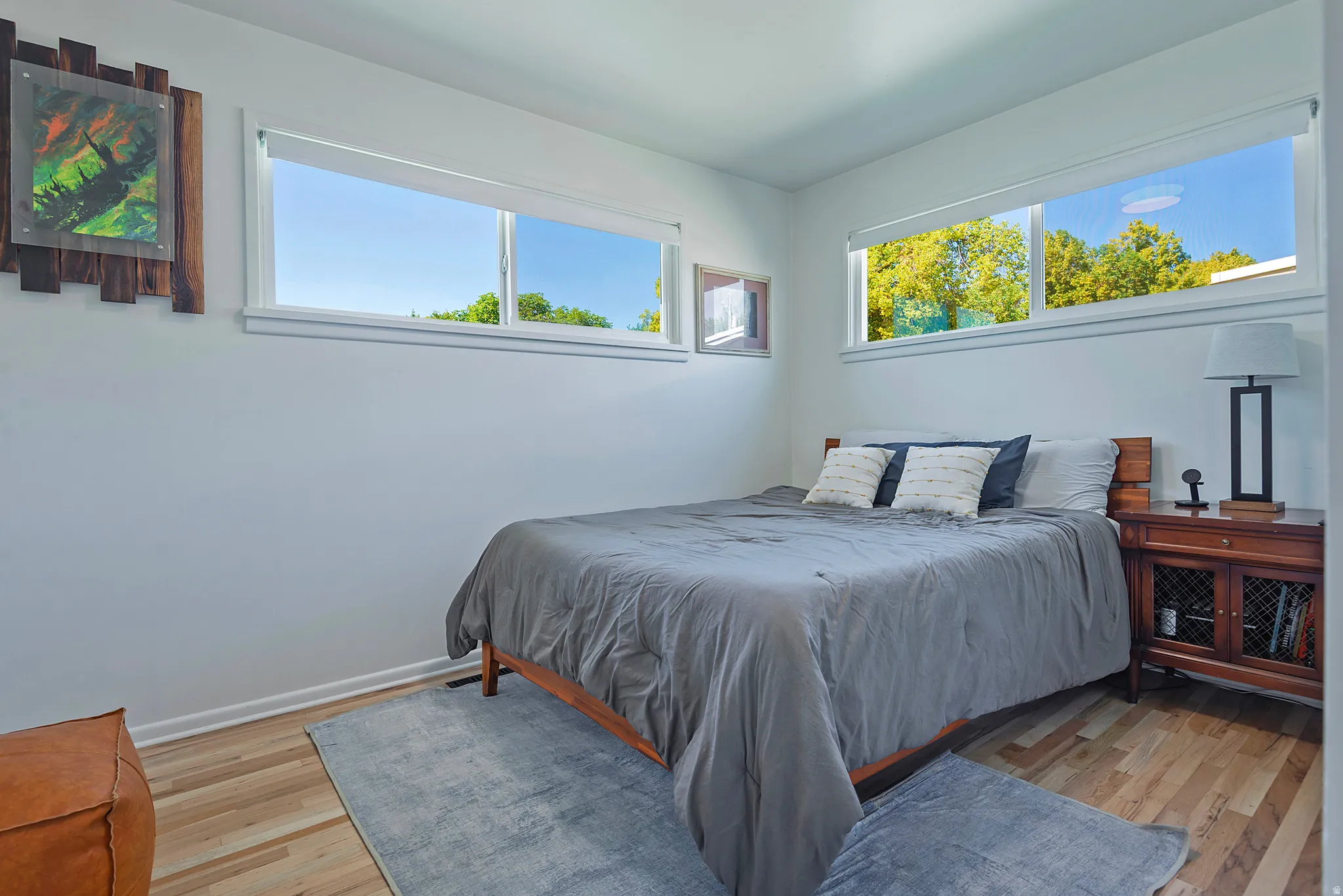 Bright interior space featuring light wood-finish flooring, white walls, and multiple horizontal windows