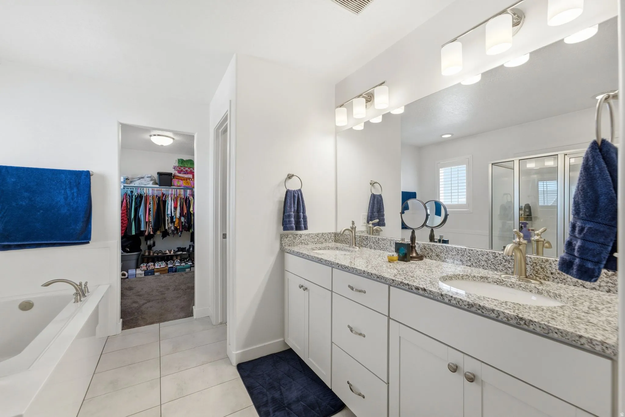 Bathroom featuring a dual vanity with granite countertops, undermount sinks, and brushed nickel fixtures