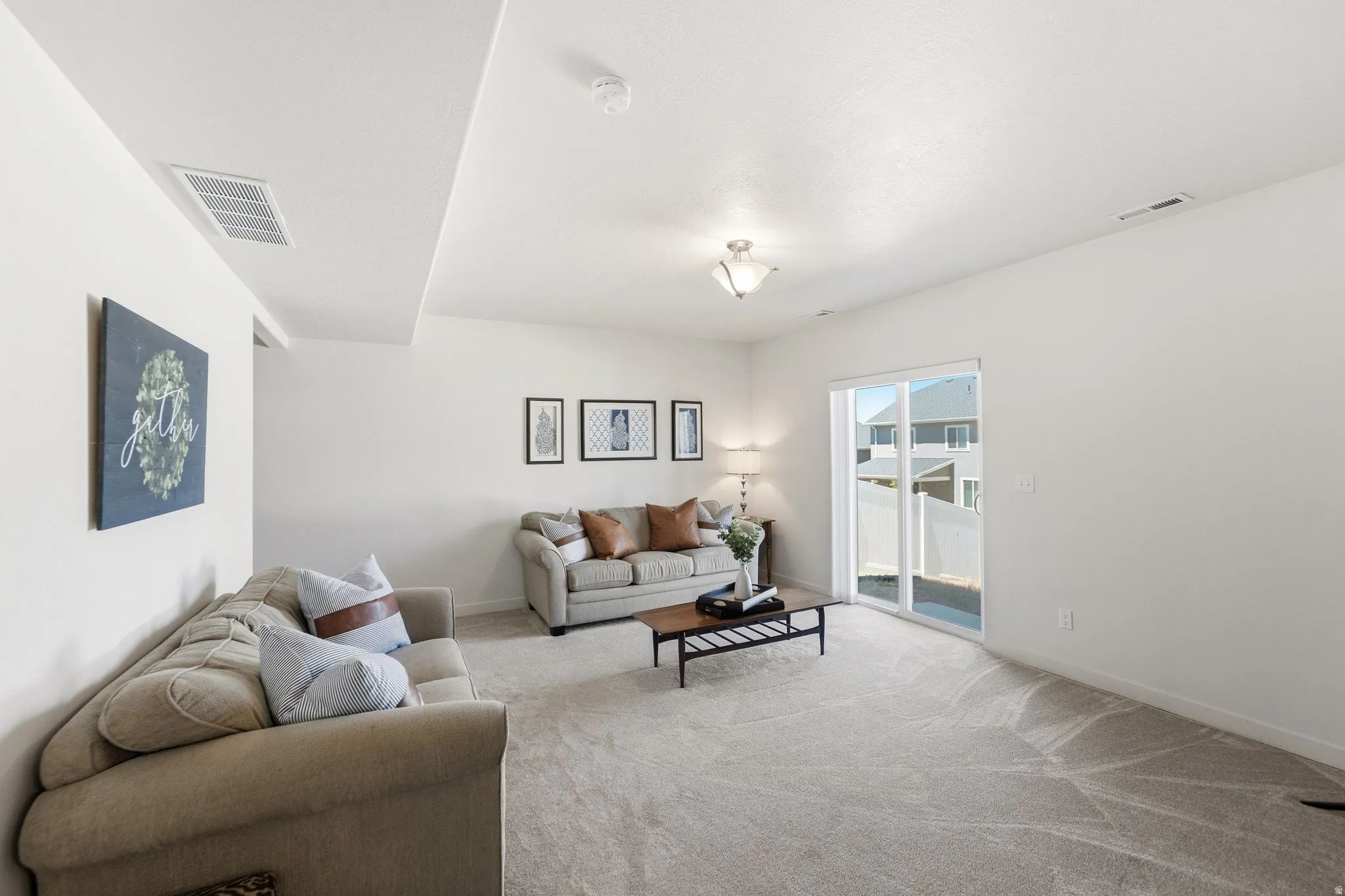 Spacious living area featuring light-toned carpeting and neutral wall tones