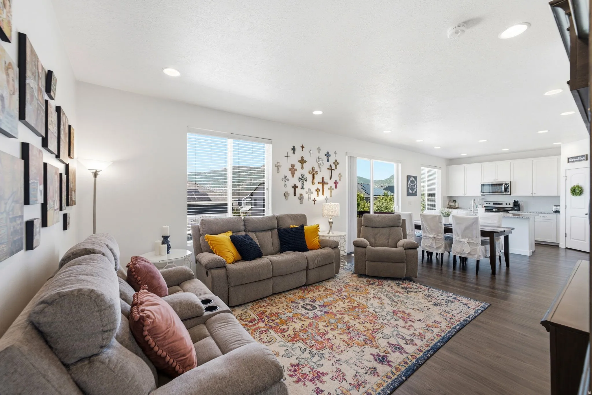 Open-concept living space featuring wood-finish flooring, recessed lighting, and large windows