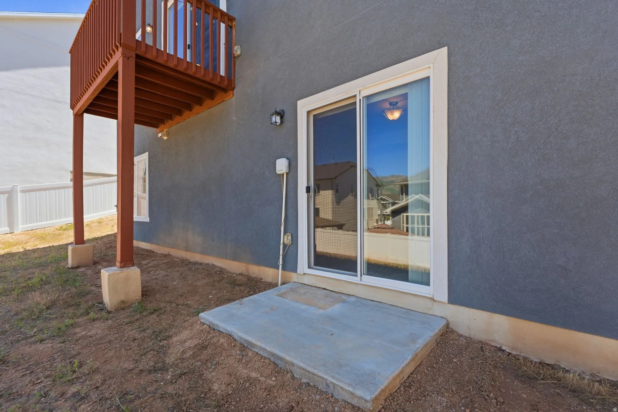 Slider door with white frame providing exterior access from lower level