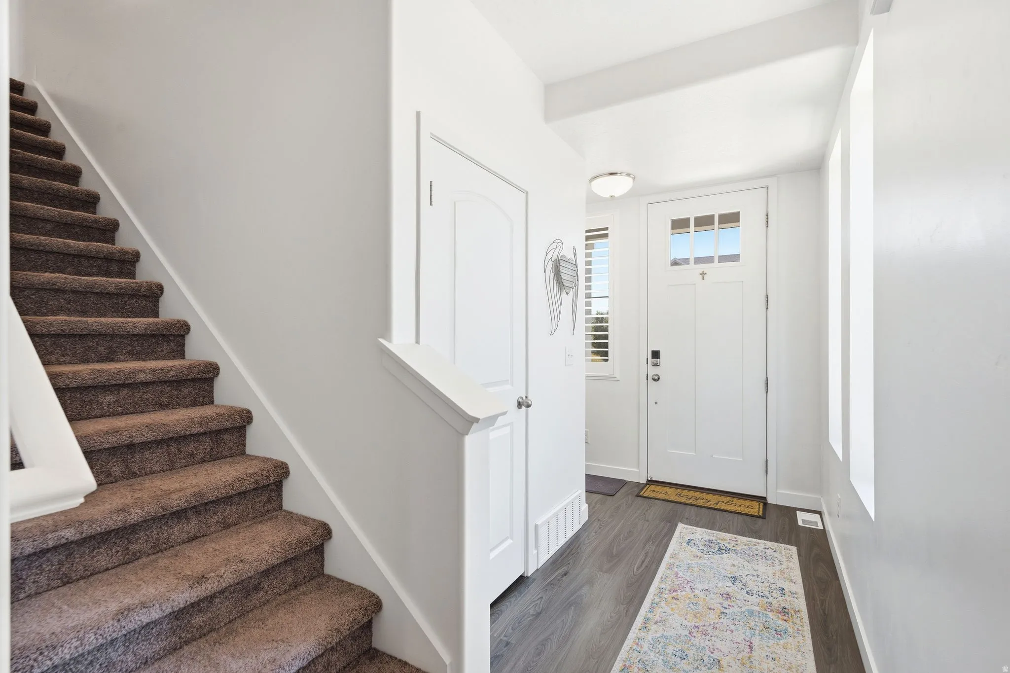 Entryway featuring a white front door with upper window panes, wood-finish flooring, and a flush mount ceiling light